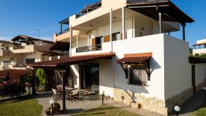 a white building with a red roof at Hemera House Minthi in Kalandra