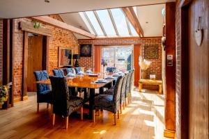 a dining room with a long table and chairs at Villa Hobland Barn in Fritton Norfolk
