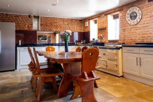 a large kitchen with a wooden table and chairs at Villa Hobland Barn in Fritton Norfolk +30 photos