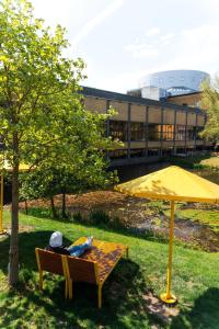 a picnic table with a yellow umbrella in a park at VANDER Aparthotel Inre Hamnen in Norrköping