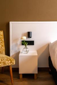 a bedroom with a bed and a table with a vase of flowers at Restaurant & Hotel Monopole Harderwijk in Harderwijk