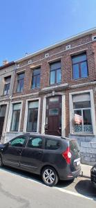 a black car parked in front of a brick building at studio dans le centre de Mons in Mons