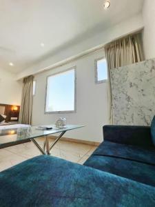 a living room with a blue couch and a glass table at HOTEL KAILASH REGENCY - Luxury Rooms Near Railway Station and Bus Terminal Ludhiana in Ludhiana