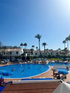 a large swimming pool with people in a resort at Duplex Duo Parque Santiago 2 in Playa de las Americas