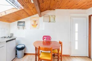 a small kitchen with a wooden table and chairs at Joli T3 Pays Basque Tarnos Landes in Tarnos