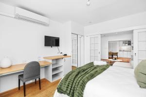 a white bedroom with a desk and a bed at The Victoria One Sepal Stays in Perth