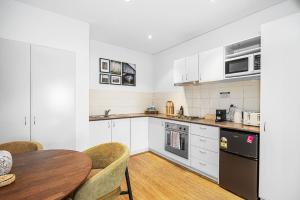 a kitchen with white cabinets and a wooden table at The Victoria One Sepal Stays in Perth +7 photos