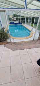 una piscina dentro de un edificio con un edificio en Chez Océane et Virgil, en La Celle-sous-Gouzon