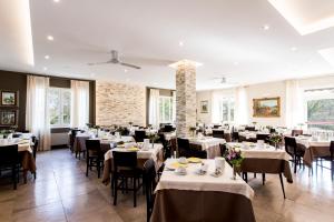 トスコラーノ・マデルノにあるHotel Sorrisoのダイニングルーム(白いテーブル、椅子付)
