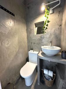 a bathroom with a white toilet and a sink at Serenity Nest Serifos in Serifos Chora