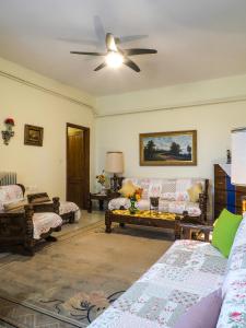 a living room with couches and a ceiling fan at Katina's Farm House in Áno Lekhónia