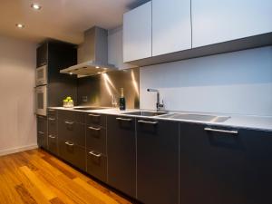 uma cozinha com armários de aço inoxidável e um lavatório em Fewdays Barcelona Apartments em Barcelona