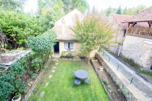 - une vue sur la cour avec une table et un parasol dans l'établissement Rue de la levade, à Daglan