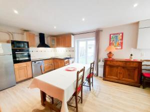 une cuisine avec une table blanche et des chaises dans l'établissement Rue de la levade, à Daglan 3 autres photos