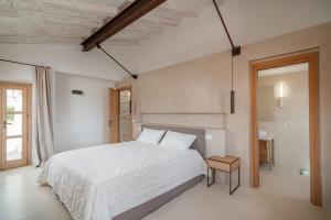 a bedroom with a large white bed in a room at Villa dell'800 con Jacuzzi Privata - San Pantaleo in San Pantaleo