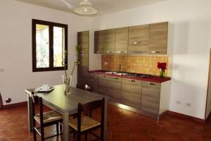 eine Küche mit einem Tisch und einem Esszimmer in der Unterkunft Yellon House in Santa Maria Navarrese