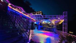 a stage lit up at night with colorful lights at Heart Beat Resort in Shivpuri