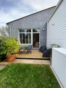 Un patio con una mesa y sillas en una terraza. en Maison 4 Personnes, jardin, piscine La Rochelle, en Lagord