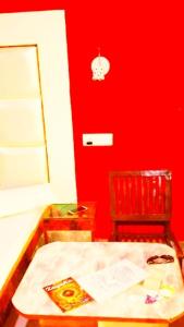 a red room with a table and a chair at Ridge Lakkar Stay in Shimla