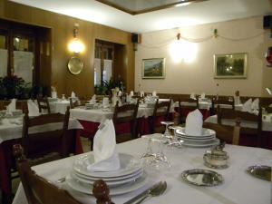 un comedor con mesas y sillas con mesas blancas en Hotel del Corso, en Sestola