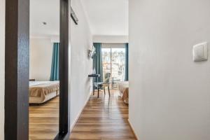 a room with two beds and a room with a mirror at White Waters Hotel in Machico