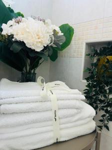 ポンペイにあるDomus Valenteのテーブルの上にタオルが積み重ねられ、花束が置かれている