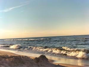 una spiaggia sabbiosa con onde nell'oceano di Domki & Pokoje Władysławowo a Władysławowo