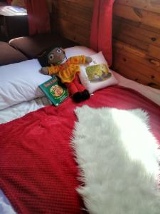 a teddy bear laying on a bed with a book at No frills narrowboat stay over experience in Lincoln