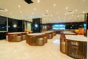 a restaurant with tables and chairs in a room at Senora Suites in Kannur