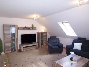 a living room with two chairs and a television at Ferienwohnung Vier Sterne in Goslar
