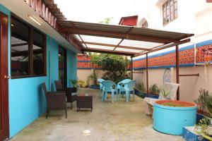 d'une terrasse avec un auvent, des chaises et une table. dans l'établissement Urban Oasis Studio with Bathtub & Garden - Vientiane Centre, à Vientiane