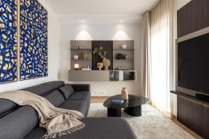 a living room with a couch and a tv at Stylish Waterfront stay with Lounge Terrace & Sauna in Tallinn