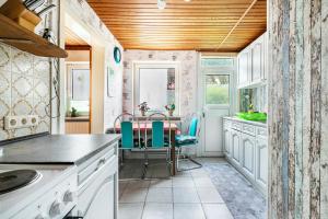 a kitchen with white cabinets and a table with chairs at Altstadt Ferienhaus mit Terrasse in Husum