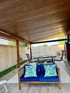 a blue couch on a patio with a table and chairs at Casa de Madera in El Palmar