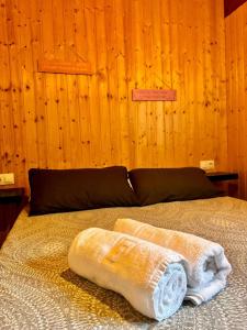 a bedroom with a bed with a wooden wall at Casa de Madera in El Palmar