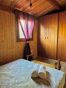 a bedroom with a bed with two towels on it at Casa de Madera in El Palmar