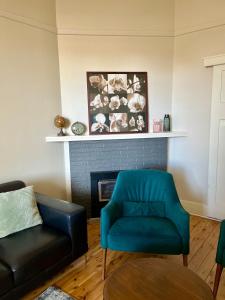 - un salon avec un fauteuil bleu et un canapé dans l'établissement Kelpie Cottage, Luxe 1930s Stay in the Heart, à Albury 23 autres photos