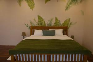 une chambre avec un lit avec une couverture verte dans l'établissement Urban Oasis Studio with Bathtub & Garden - Vientiane Centre, à Vientiane