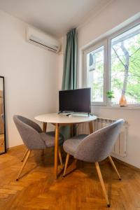 a table with two chairs and a laptop on it at Central Sofia Gem by Vitoshka Street in Sofia