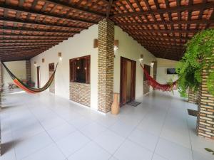 Una habitación con techo de madera y suelo de baldosas blancas. en Vila Jatobá Lençóis, en Santo Amaro