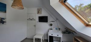 a white room with a desk and a window at Maison bretonne proche plage in Pénestin