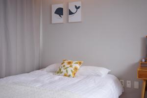 a white bed with a pillow on top of it at Aewol Bada 23 in Jeju