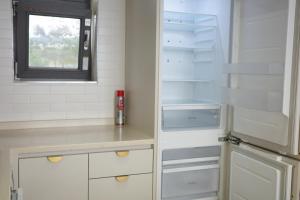 a kitchen with white cabinets and an empty refrigerator at Aewol Bada 23 in Jeju +39 photos
