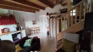 a living room with a staircase and a kitchen at Maisonette en Cévennes in Notre-Dame-de-la-Rouvière