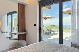 a bedroom with a bed and a view of the ocean at Four Horizons Luxury Villas in Kournás +122 photos