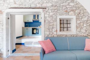 a blue couch in a living room with a stone wall at JAR - Apartments in Castion Veronese