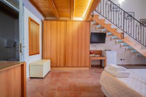 a room with a staircase with a bed and a television at Himera Domus 2 in Termini Imerese