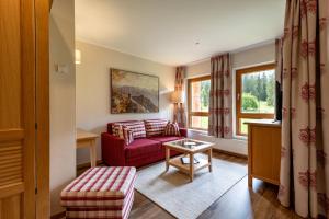 a living room with a red couch and a table at Alpenvital Tirol Appartements in Pertisau +40 photos