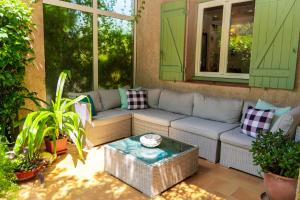 a patio with a couch and a table at Hotel Les Oliviers in Draguignan