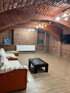 a brick room with a couch and a coffee table at Casa Seren in Corabia